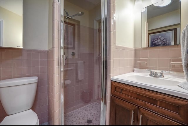 bathroom with toilet, a shower with shower door, and tile walls