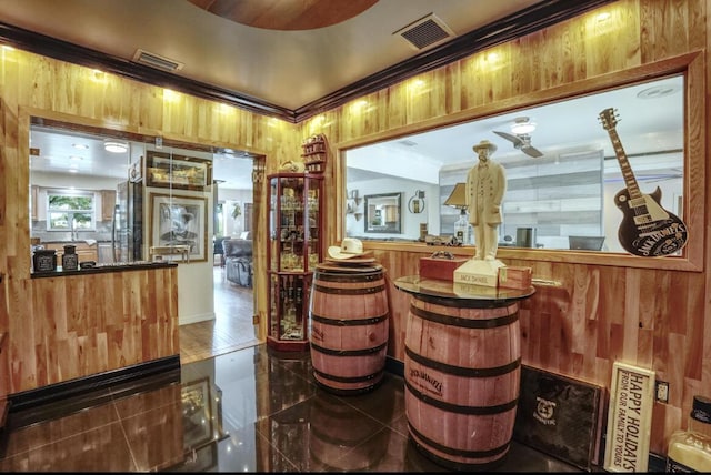 bar with ornamental molding and wood walls