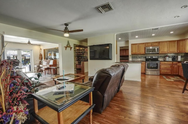 living room with ceiling fan, french doors, and hardwood / wood-style flooring