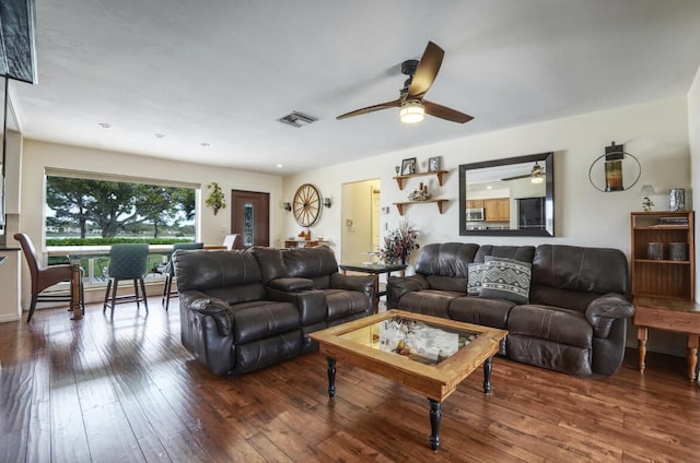 living room featuring ceiling fan and dark wood-type flooring