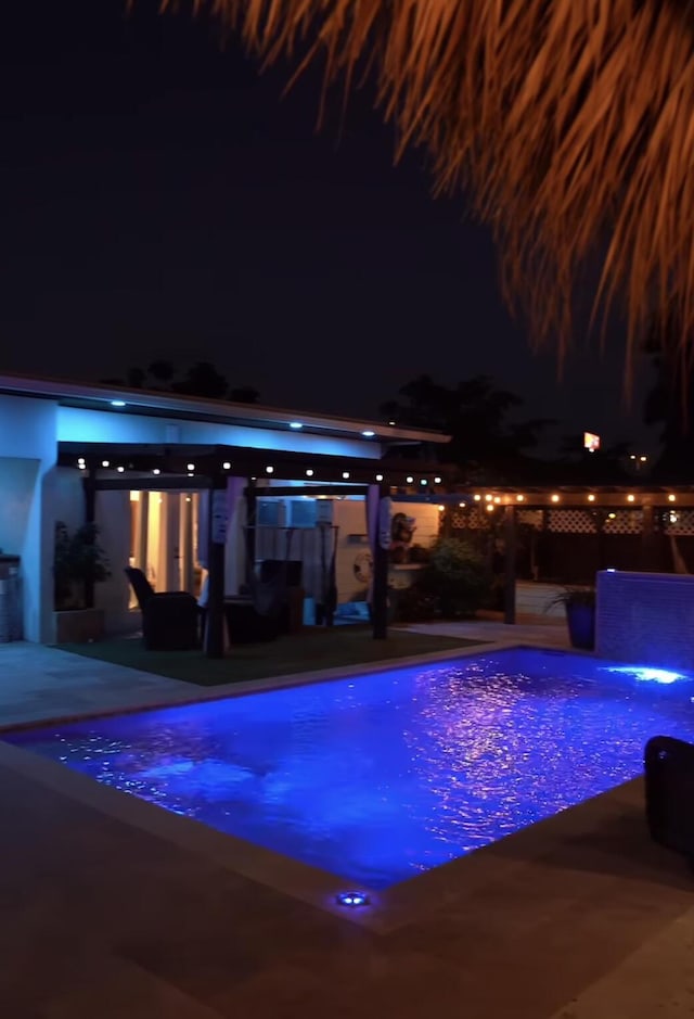 pool at twilight featuring an outdoor living space and a patio area