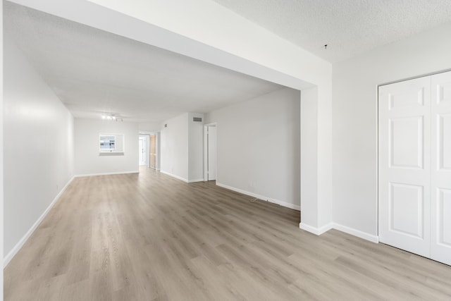 empty room featuring light wood-type flooring and a textured ceiling