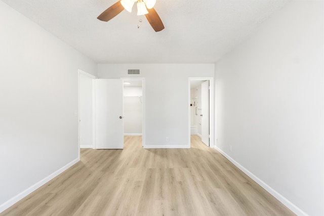 empty room with ceiling fan and light hardwood / wood-style floors