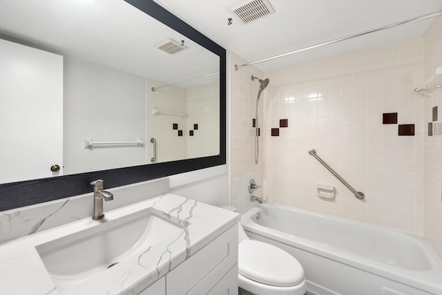 full bathroom with tiled shower / bath, vanity, and toilet