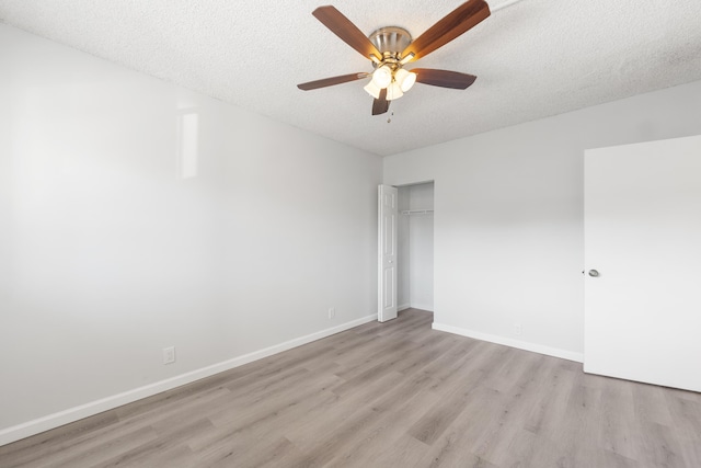 spare room featuring ceiling fan, light hardwood / wood-style flooring, and a textured ceiling