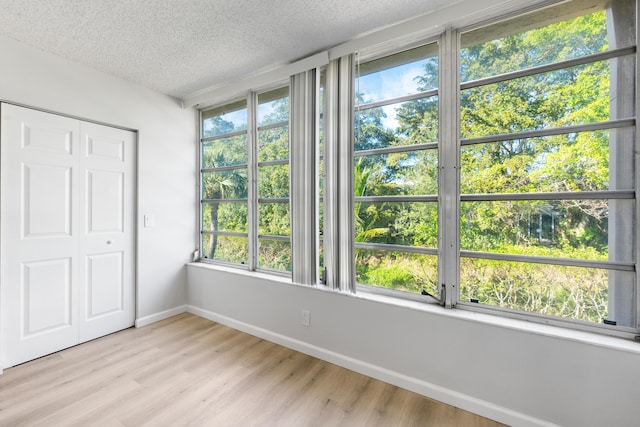 unfurnished bedroom with a closet, a textured ceiling, and light hardwood / wood-style flooring