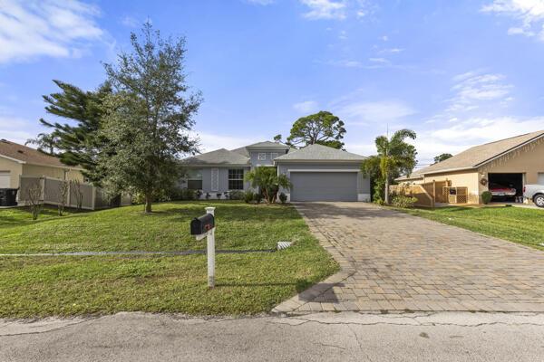 ranch-style house featuring a front lawn and a garage