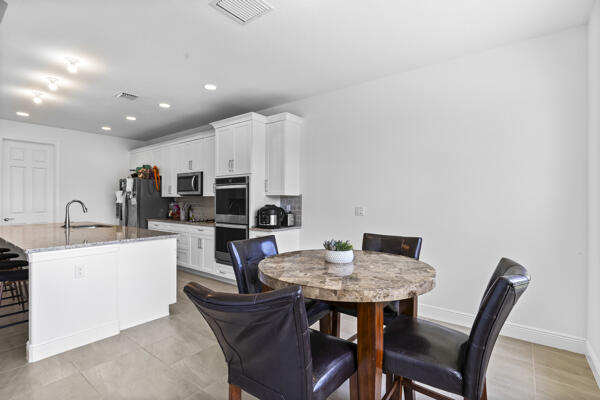 kitchen with white cabinets, sink, an island with sink, and appliances with stainless steel finishes