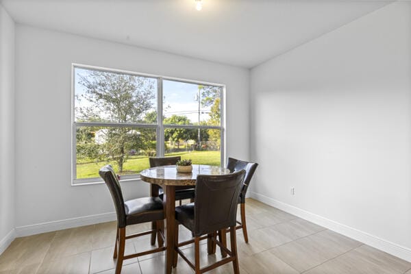 dining space with light tile patterned flooring and a healthy amount of sunlight