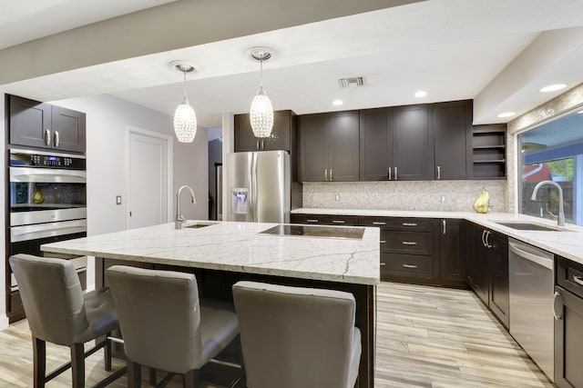 4360 SE Kubin Ave, Stuart, FL 34997 - kitchen with appliances with stainless steel finishes, a breakfast bar area, decorative backsplash, and a sink