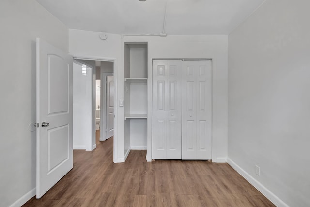 unfurnished bedroom featuring light wood-type flooring and a closet