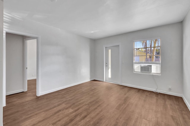 unfurnished room featuring cooling unit and light wood-type flooring