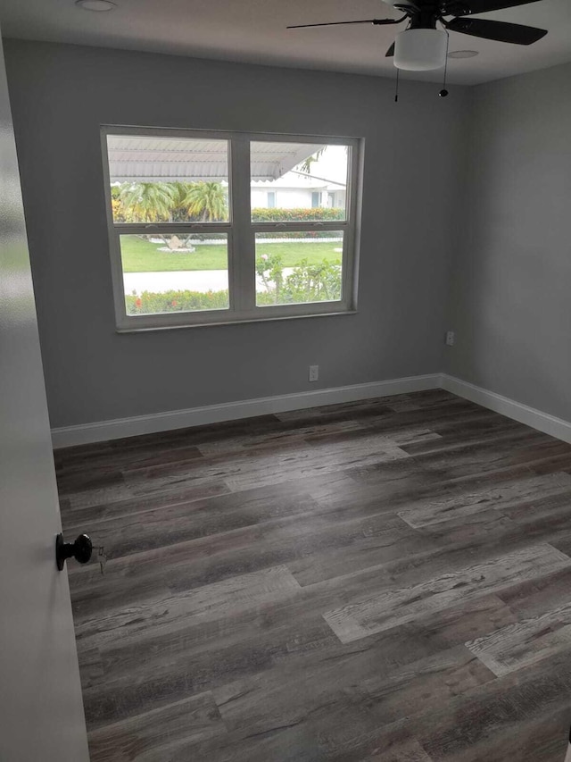 empty room featuring ceiling fan and dark hardwood / wood-style flooring