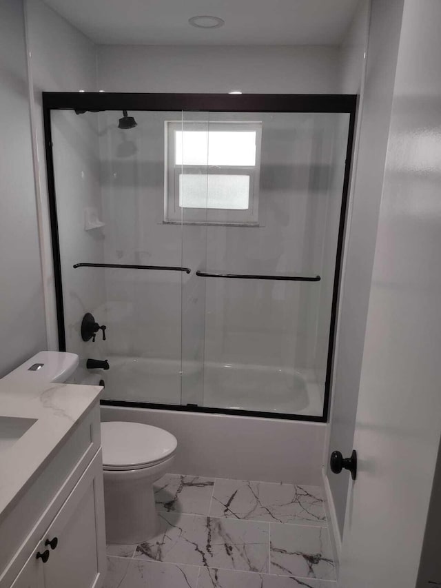 full bathroom featuring combined bath / shower with glass door, vanity, and toilet