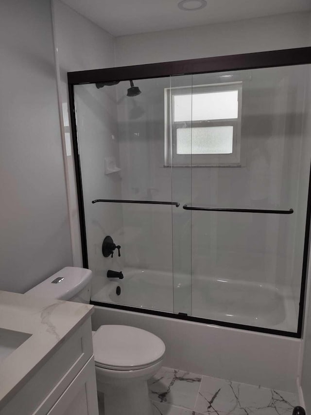 full bathroom with vanity, bath / shower combo with glass door, and toilet