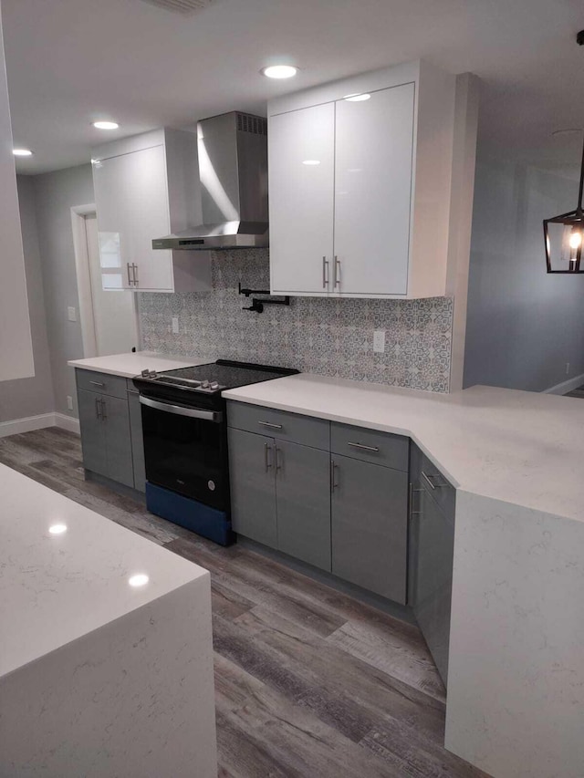 kitchen with black range with electric cooktop, gray cabinets, white cabinetry, and wall chimney range hood