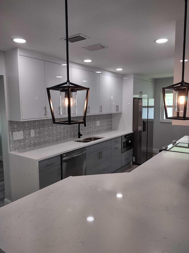 kitchen featuring dishwasher, built in microwave, gray cabinetry, and fridge with ice dispenser