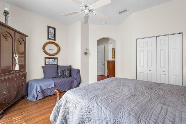 bedroom featuring ceiling fan, a closet, hardwood / wood-style floors, and a textured ceiling