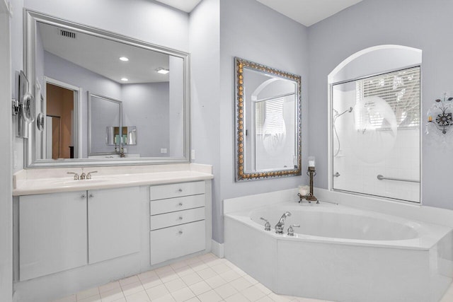 bathroom with tile patterned floors, vanity, and a bath