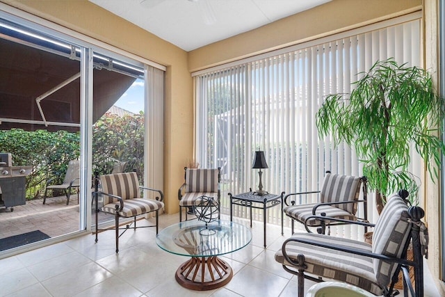 living area with ceiling fan and light tile patterned flooring