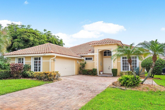 mediterranean / spanish house with a front yard and a garage