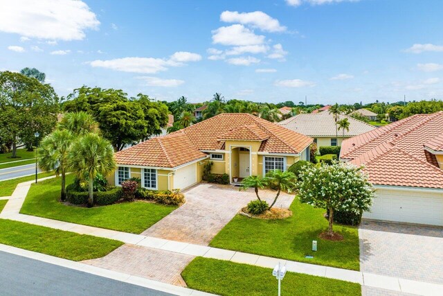 mediterranean / spanish-style house featuring a garage and a front lawn