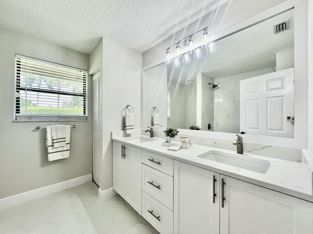 bathroom featuring a textured ceiling, vanity, and walk in shower