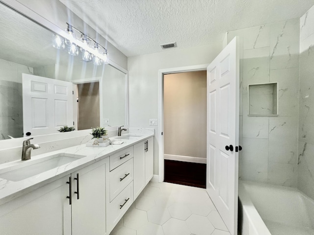 bathroom featuring tile patterned floors, vanity, and a textured ceiling