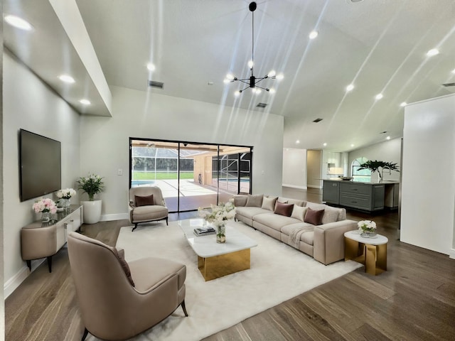 living room featuring wood-type flooring and an inviting chandelier