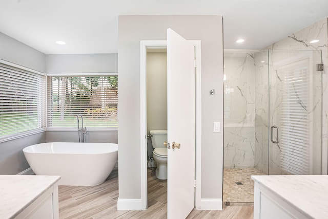 full bathroom with hardwood / wood-style flooring, vanity, independent shower and bath, and toilet