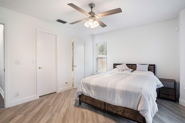 bedroom featuring ensuite bath, ceiling fan, and light hardwood / wood-style flooring