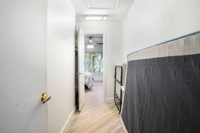 hall featuring light hardwood / wood-style floors and a textured ceiling