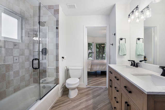 full bathroom with hardwood / wood-style floors, vanity, a healthy amount of sunlight, and toilet