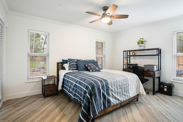 bedroom featuring multiple windows, ceiling fan, and ornamental molding