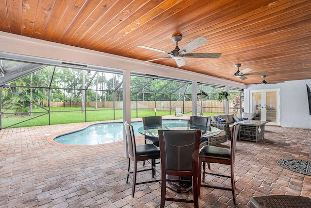 view of swimming pool with a lawn, french doors, ceiling fan, a lanai, and a patio area