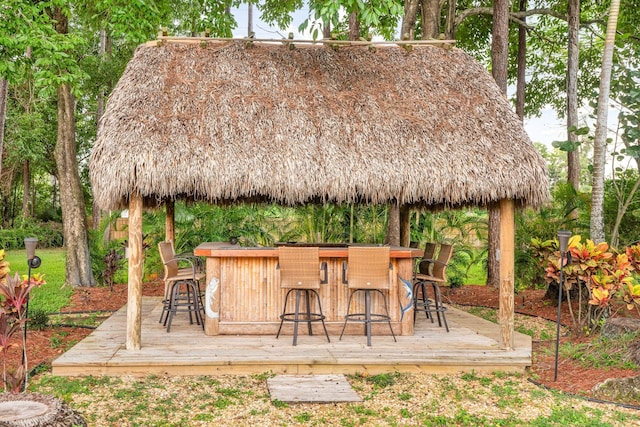 view of patio featuring a gazebo, exterior bar, and a deck