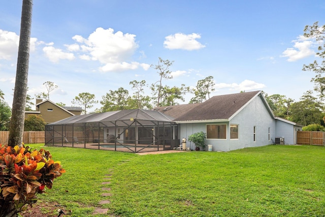 rear view of house featuring a lanai, a yard, cooling unit, and a fenced in pool