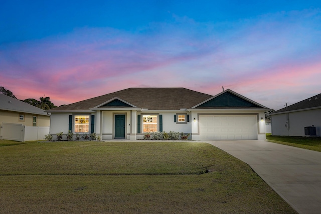 ranch-style home with a lawn, cooling unit, and a garage