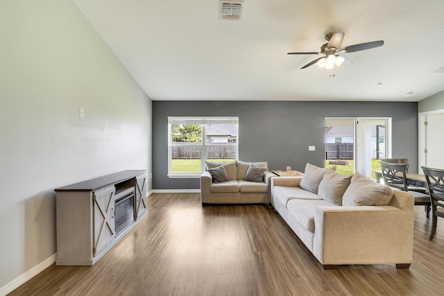 living room featuring ceiling fan and dark hardwood / wood-style flooring