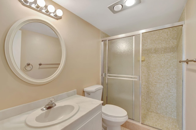 bathroom featuring sink, a shower with shower door, and toilet