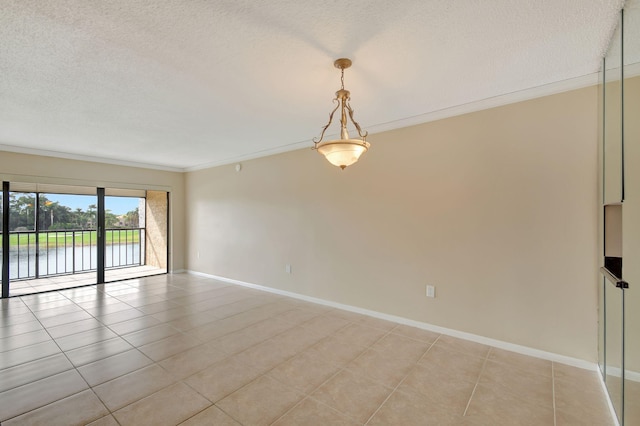 spare room featuring crown molding, a water view, light tile patterned floors, and a textured ceiling