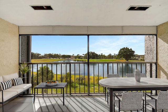 sunroom featuring a water view and a healthy amount of sunlight