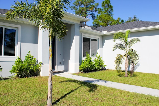 view of exterior entry featuring a yard