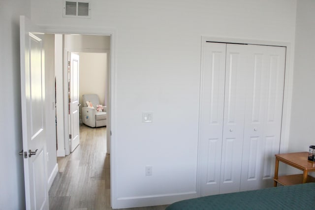 bedroom with wood-type flooring and a closet