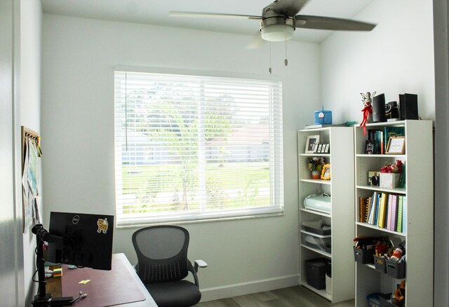 home office with ceiling fan and light hardwood / wood-style floors