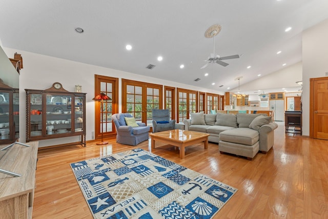 living room with ceiling fan, light hardwood / wood-style floors, high vaulted ceiling, and french doors