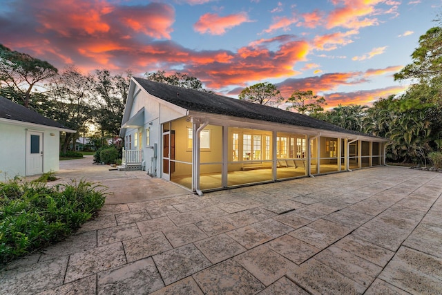 back house at dusk with a patio