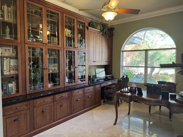 tiled home office featuring ceiling fan, ornamental molding, and built in desk