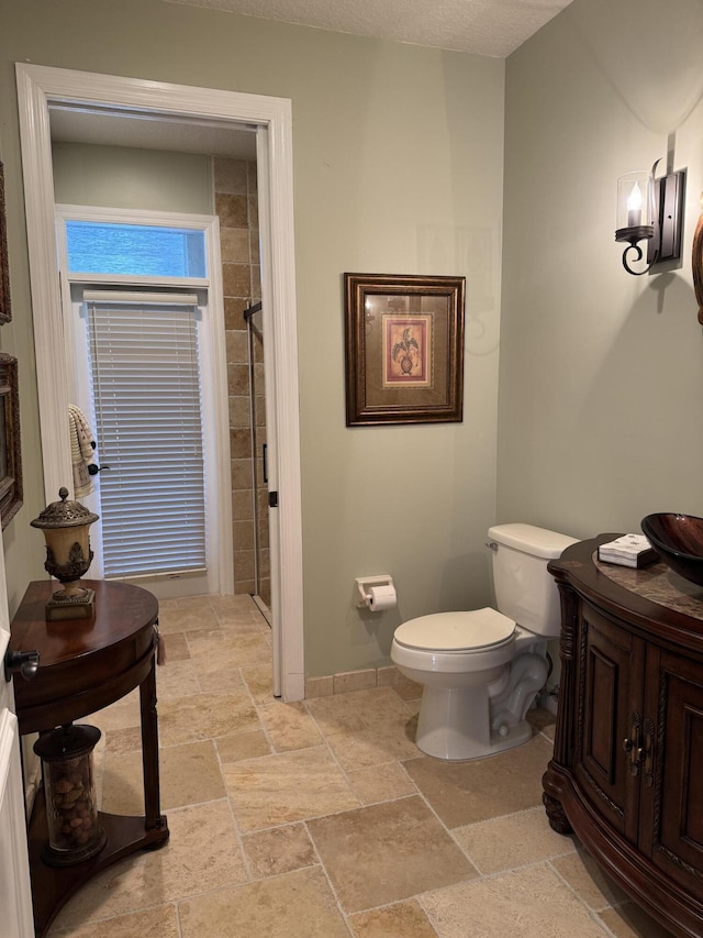 bathroom with tiled shower and toilet