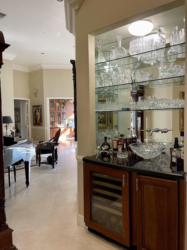 bar featuring light tile patterned flooring, beverage cooler, dark stone counters, crown molding, and a textured ceiling